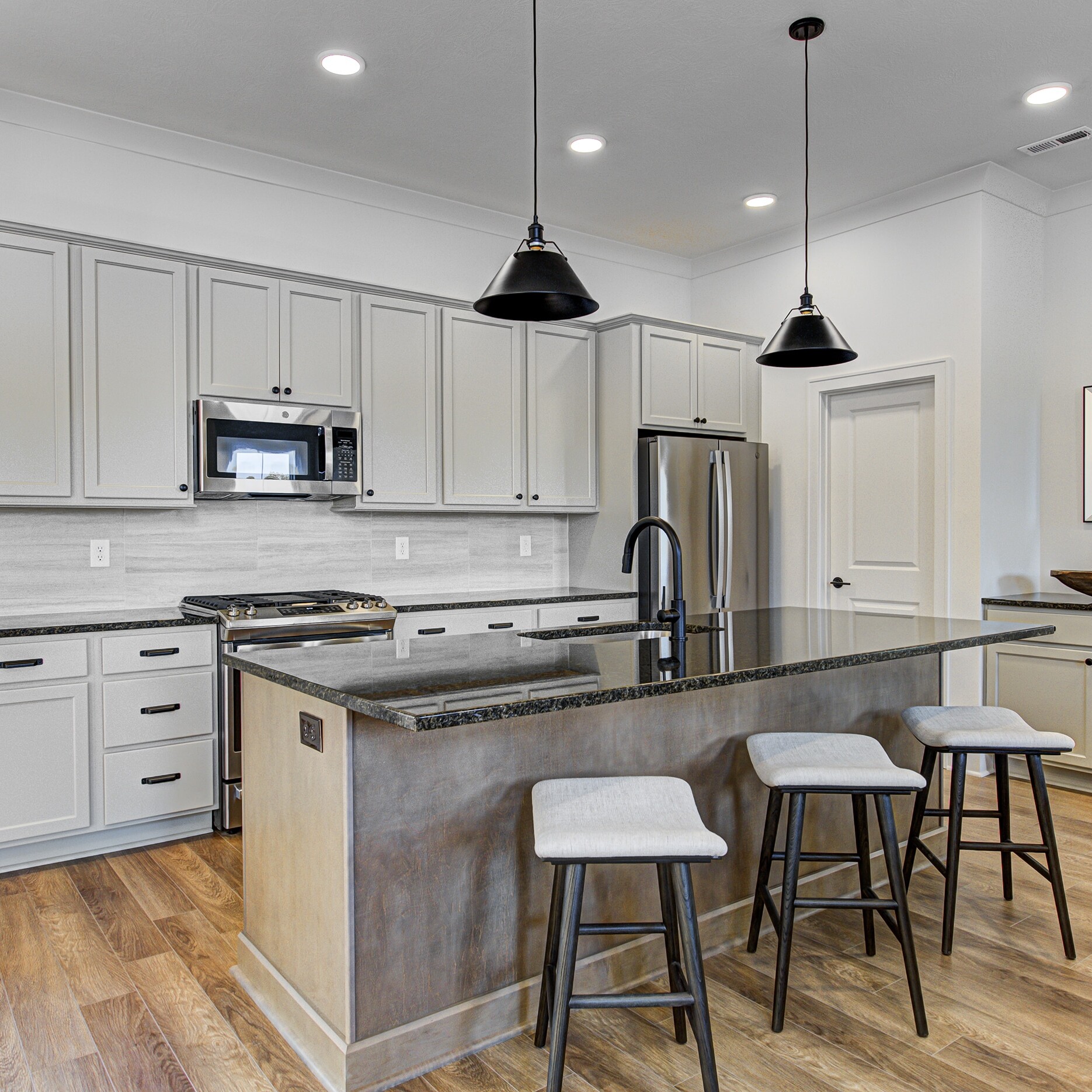 A kitchen with a center island and stools.