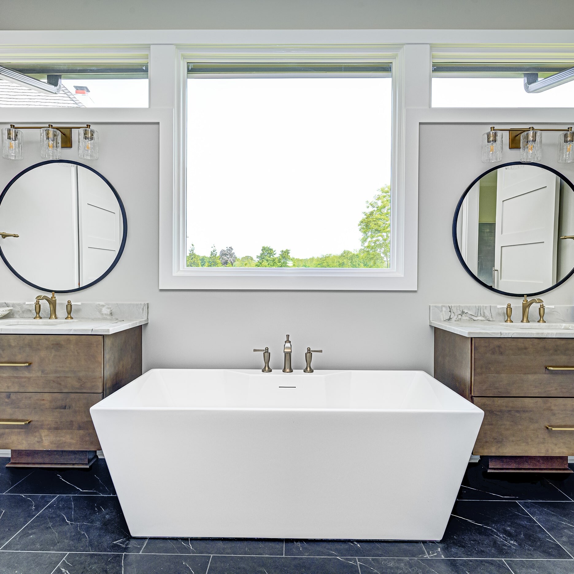 A bathroom with two sinks and a tub.