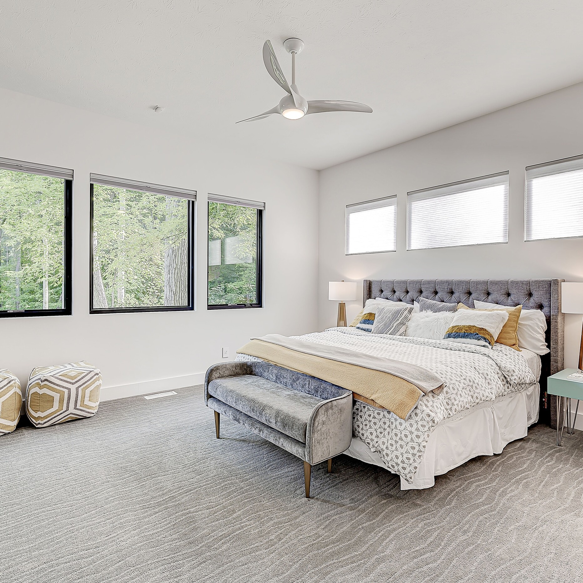 A bedroom with a large bed and a ceiling fan.