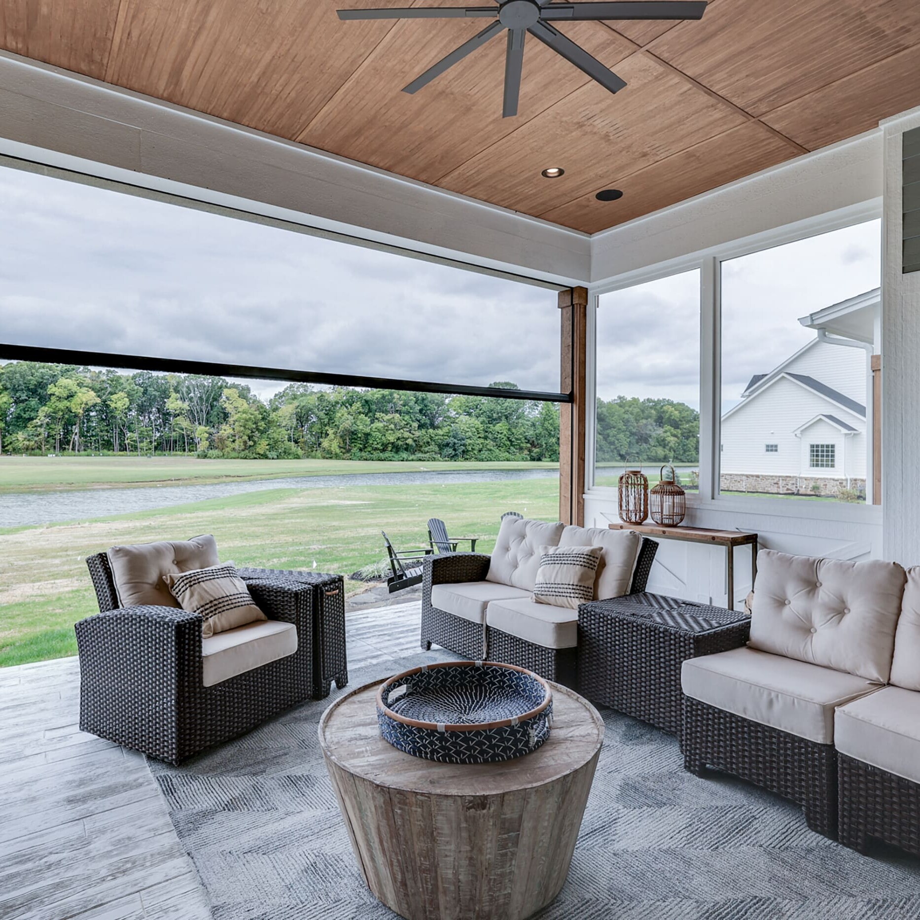 A covered patio with wicker furniture and a fireplace.