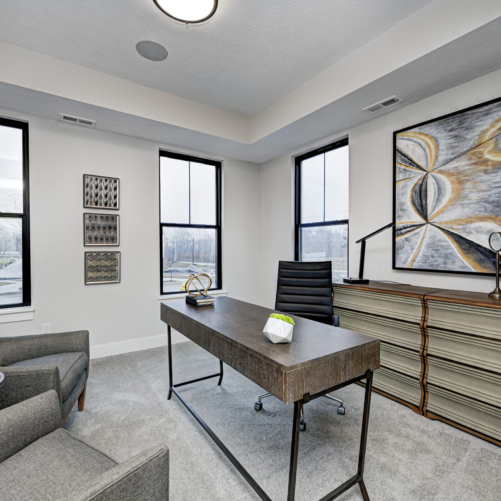 A home office with a desk and chair, designed and built by a reputable custom home builder in Indiana.