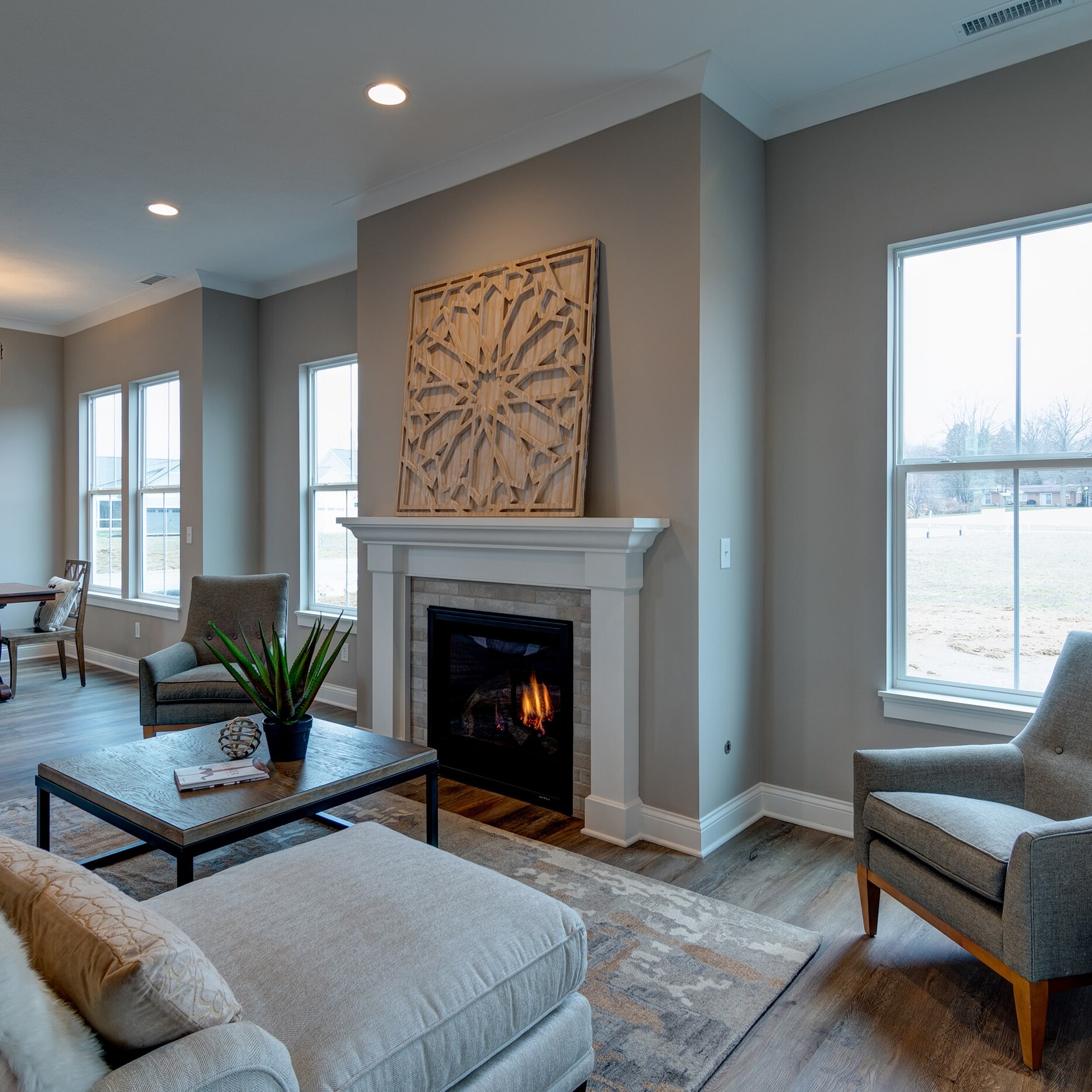 A living room with a fireplace and large windows.