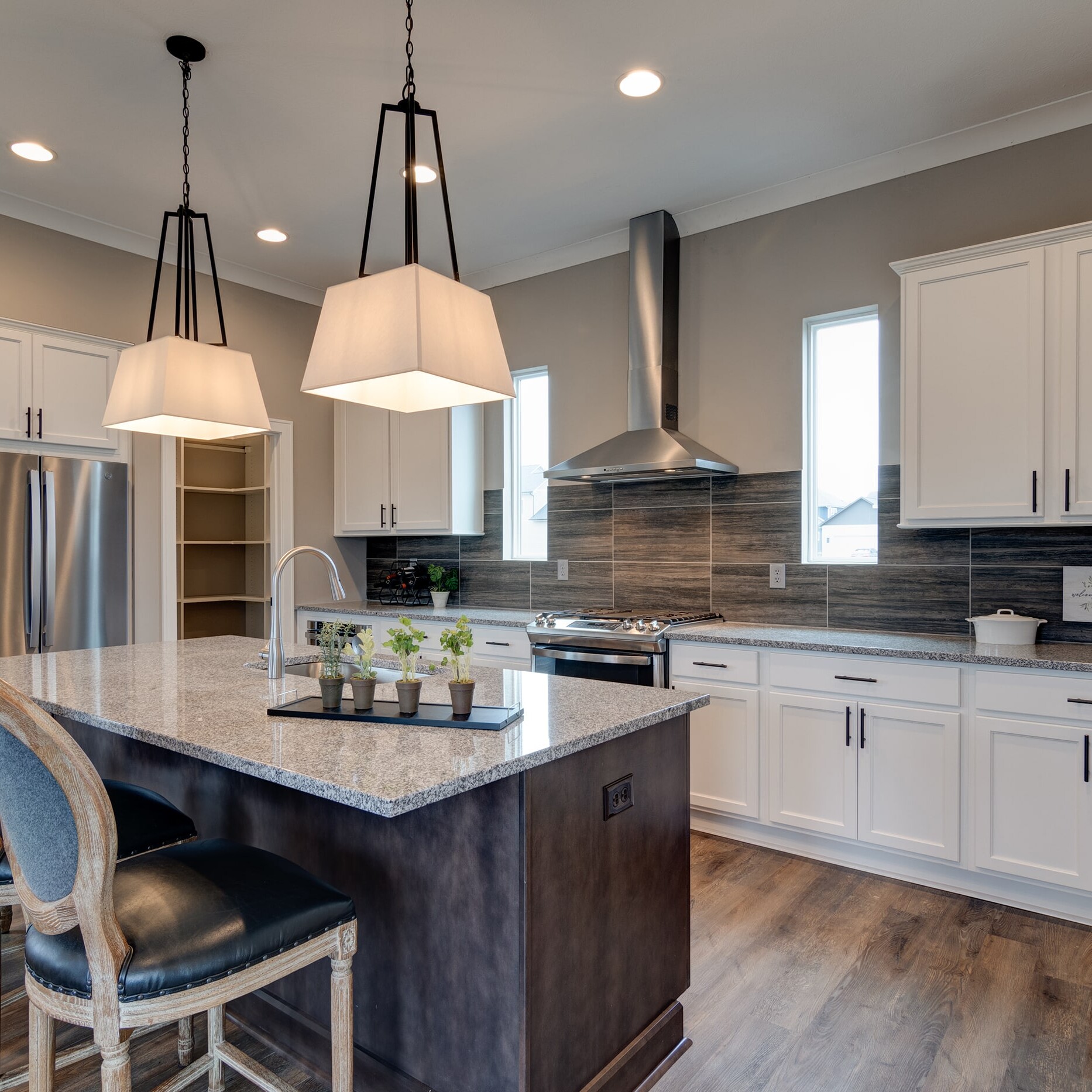 A kitchen with a center island and bar stools.