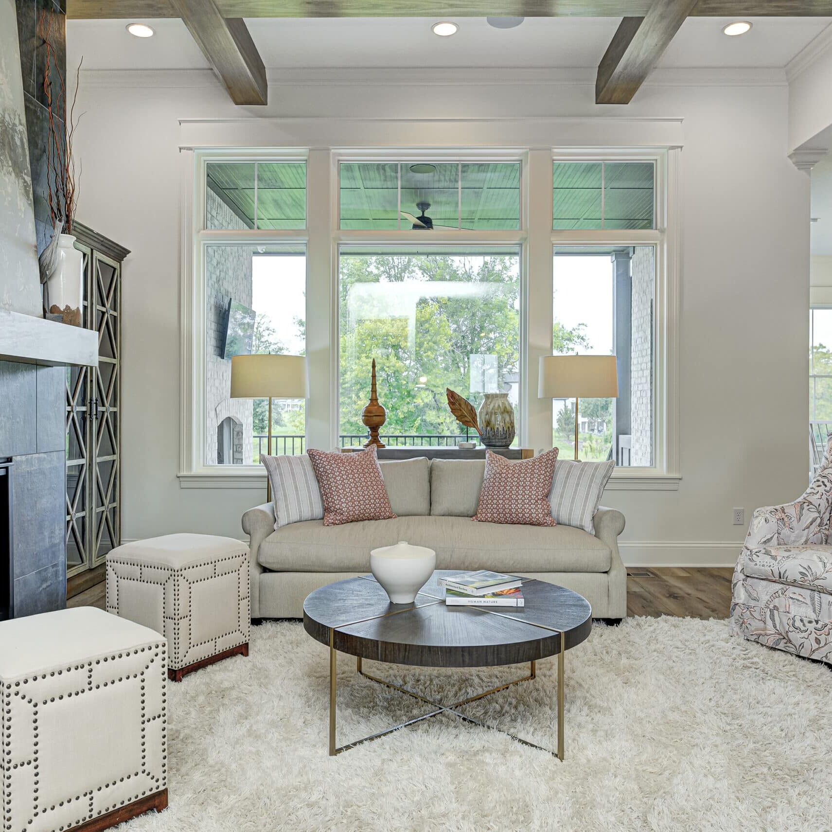 A living room with a cozy fireplace in a new custom-built home in Carmel, Indiana by an expert Indianapolis custom home builder.