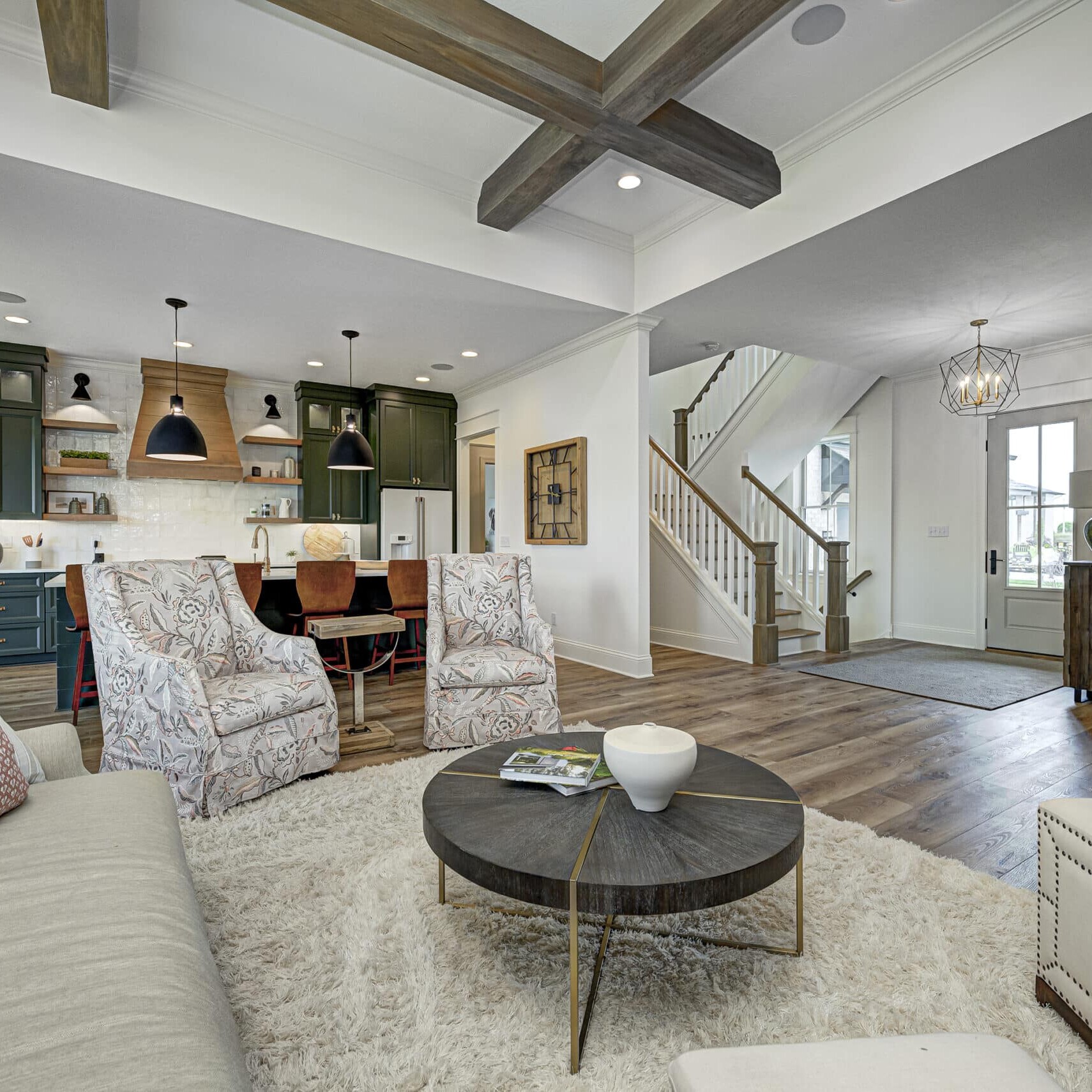 This is a stunning living room featuring beautiful hardwood floors and an elegant staircase.