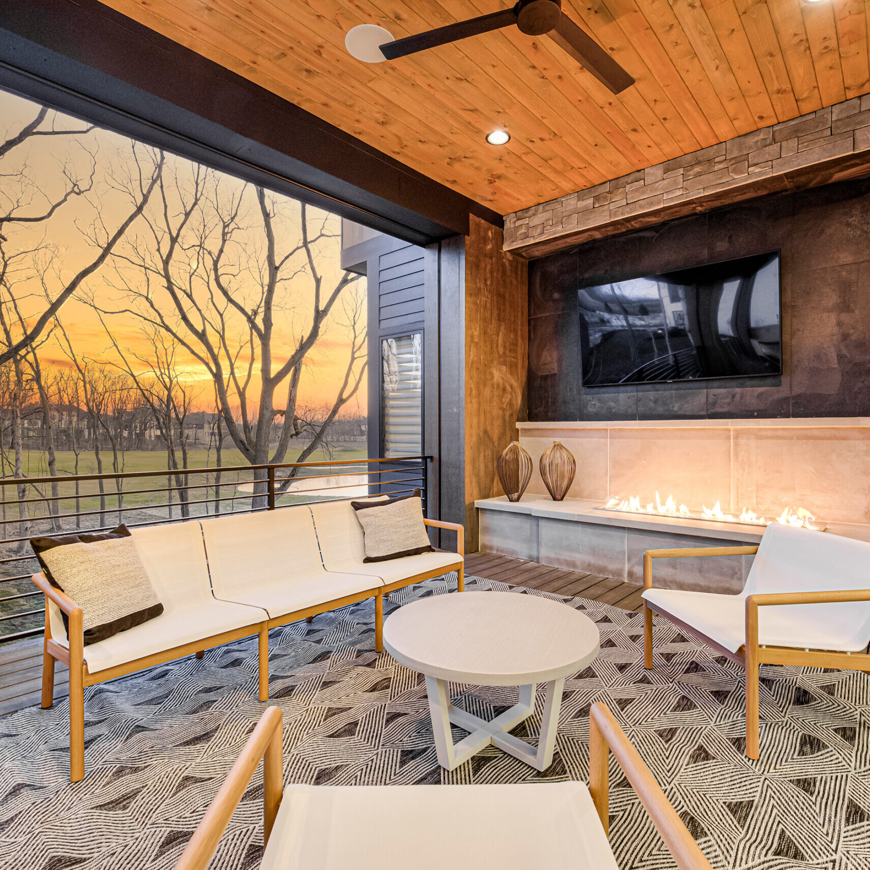 An outdoor living area with a fireplace and tv.