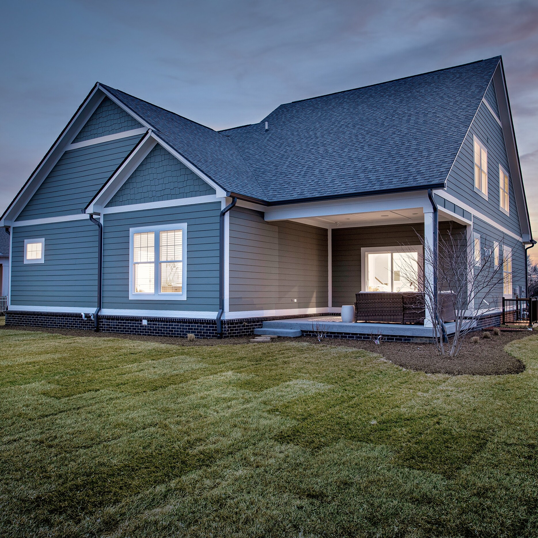 A house with a grassy yard at dusk.